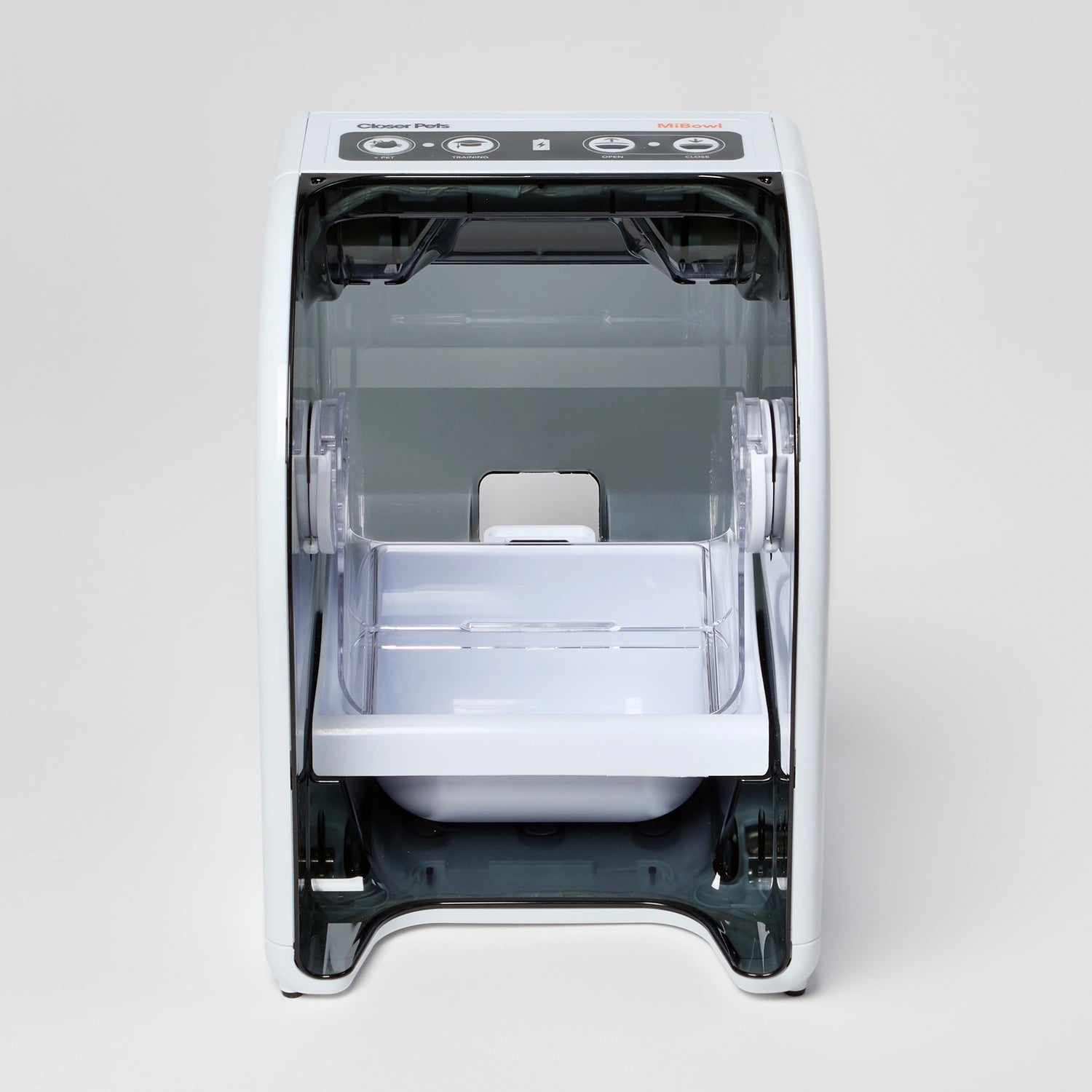 A white plastic food tray inside a white and black plastic enclosed feeding stand with visible brand logo on a white background