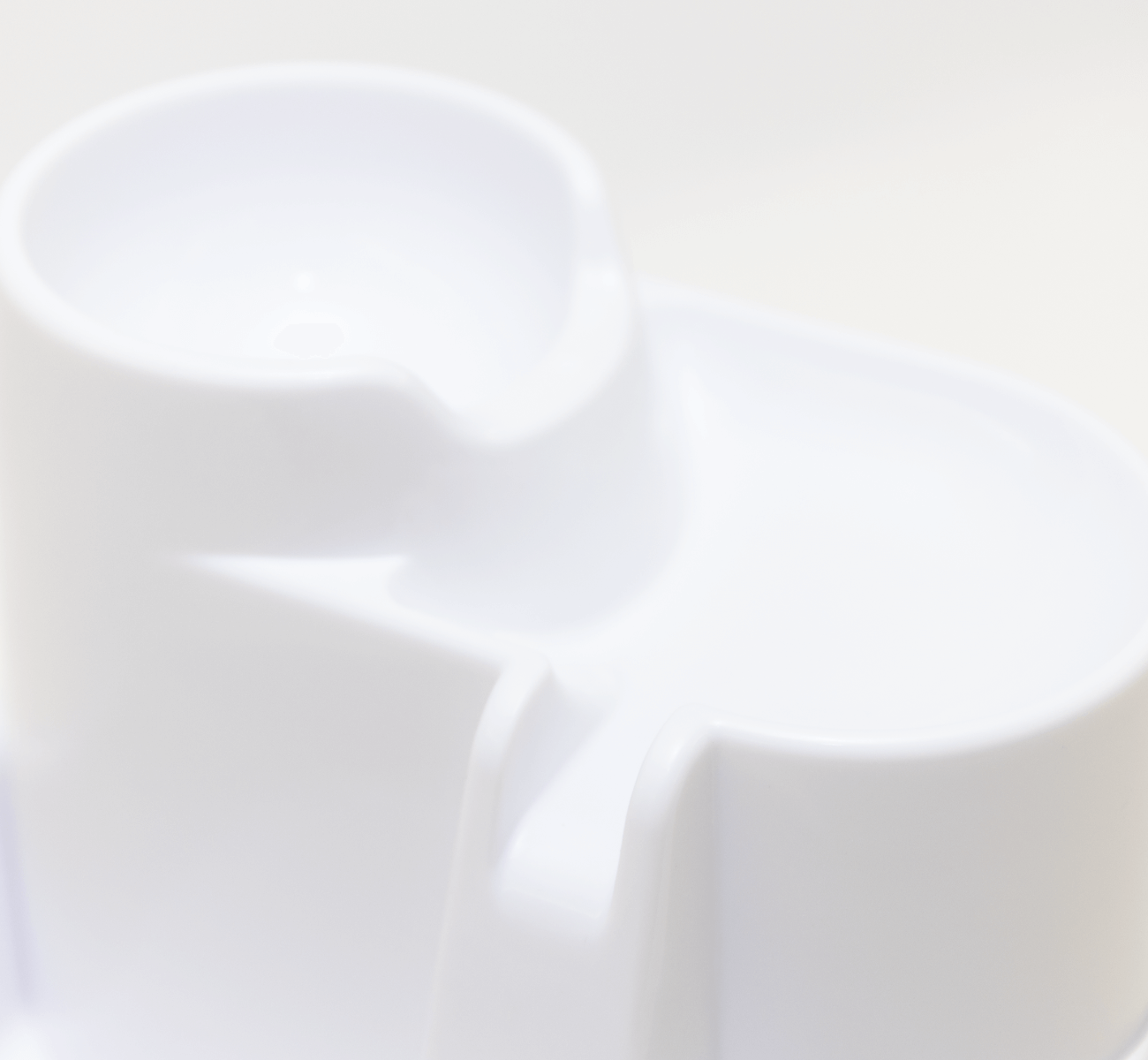 A close-up view of the first two levels of the drinking fountain for cats and dogs in white,