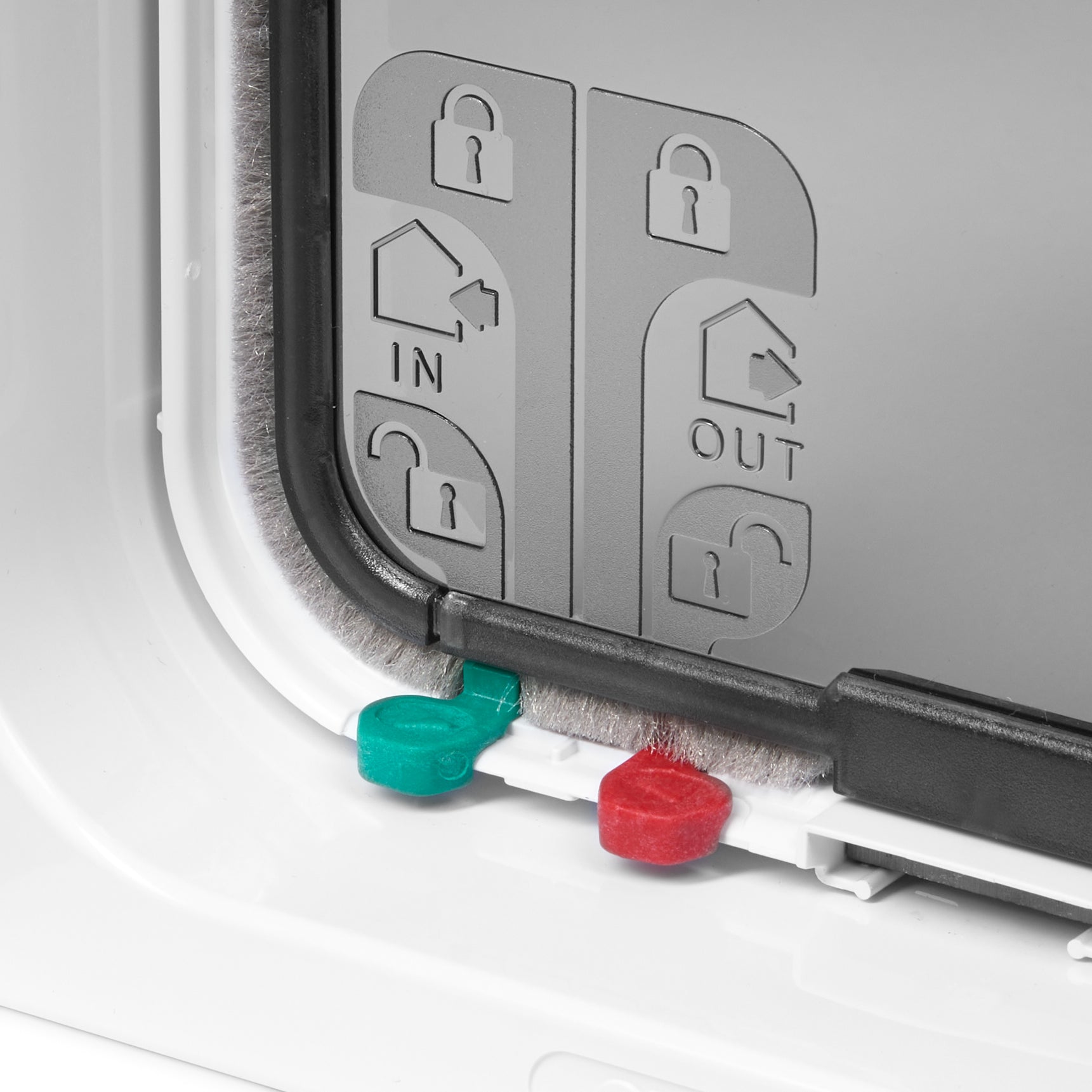 Close-up view of two out of the four red and green manual locks which provide four different manual locking options on the pet door with a white frame 