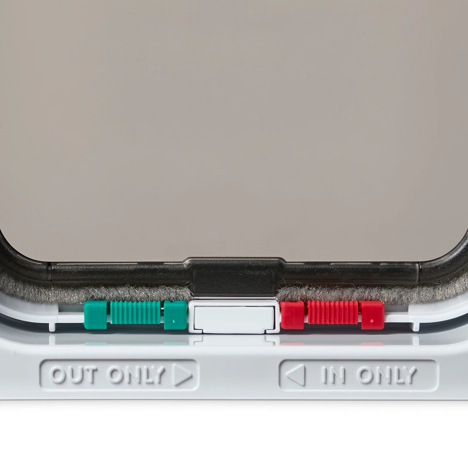 Close-up of the locks on the pet door with 'OUT ONLY' and 'IN ONLY' labels on a white  background